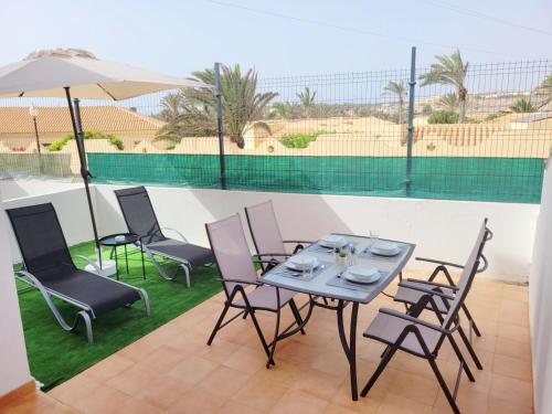 patio con tavolo, sedie e ombrellone di Casa Sol y Mar a Costa Calma