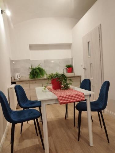 a dining room table with blue chairs and a red and white table at Urban Nest Apartments Szewska 21-R in Krakow