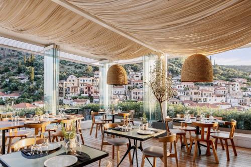 a restaurant with tables and chairs and large windows at LAS HOTEL & SPA in Gythio