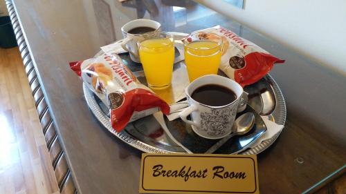 - un plateau avec deux verres de jus d'orange et une assiette avec un plateau de petit-déjeuner dans l'établissement Bucharest Boutique Accommodation by Hotels, à Bucarest