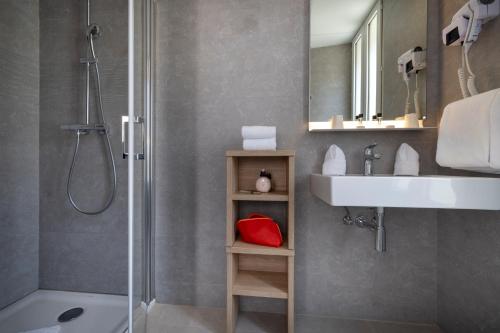 y baño con ducha, lavamanos y ducha. en Hotel Charlemagne en Neuilly-sur-Seine