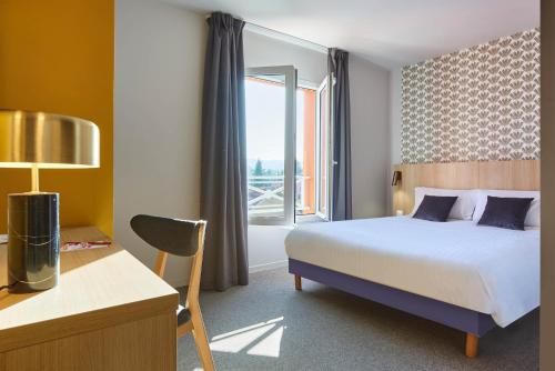 une chambre d'hôtel avec un lit et une fenêtre dans l'établissement Originals Boutique, Hôtel Larivaut, Puy-Guillaume, à Puy-Guillaume
