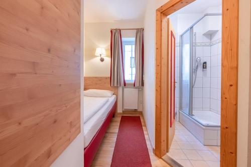 a small room with a bed and a bathroom at Hotel Eder in Munich
