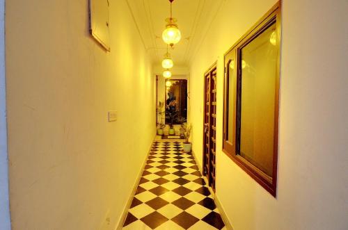 a hallway with a black and white checkered floor at Hotel Darbargarh A Unit of Khamma Ghani A Boutique Hotel in Udaipur
