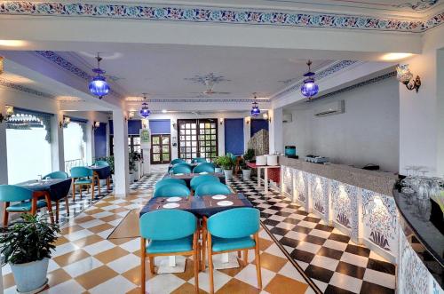 a restaurant with a long table and blue chairs at Hotel Darbargarh A Unit of Khamma Ghani A Boutique Hotel in Udaipur