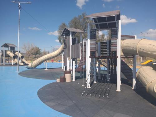 um parque infantil com um escorrega aquático num parque em IAUE EL HOGAR, una habitacion cocina,baño, estacionamiento compartido y patio em Luján de Cuyo