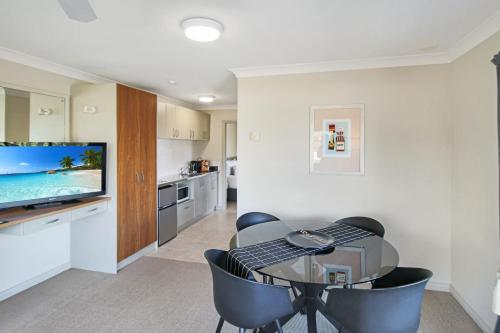 a living room with a table and a television at Whangaparaoa Lodge in Whangaparaoa