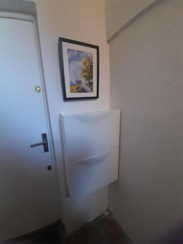 una puerta blanca en una habitación con una foto en la pared en La petite Pèlerine en Narbona