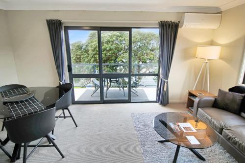 a living room with a couch and a table at Whangaparaoa Lodge in Whangaparaoa