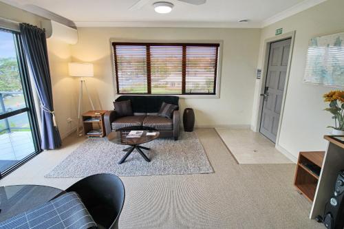 a living room with a couch and a table at Whangaparaoa Lodge in Whangaparaoa