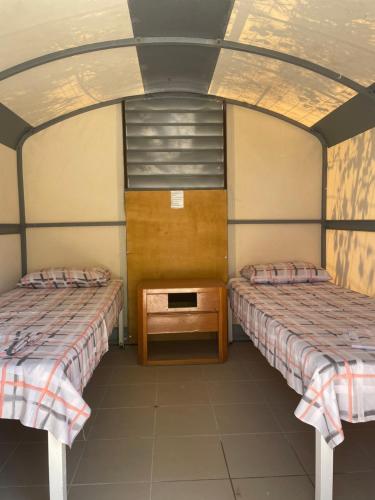 a room with two beds and a table in it at Santorini Camping & Hostel in Fira