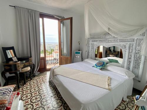 a bedroom with a large white bed and a piano at Buenavista & Suites in Santa Eularia des Riu