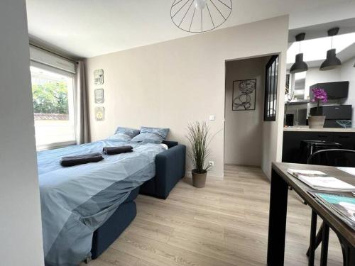 a bedroom with a blue bed and a table at Manhattan, Appartement calme in Reims