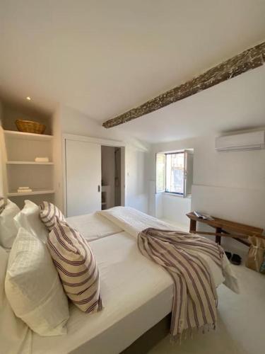 a white bedroom with a large bed with pillows at Casa Buganvilla in Alcácer do Sal