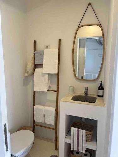a bathroom with a sink and a mirror and a toilet at Casa Buganvilla in Alcácer do Sal