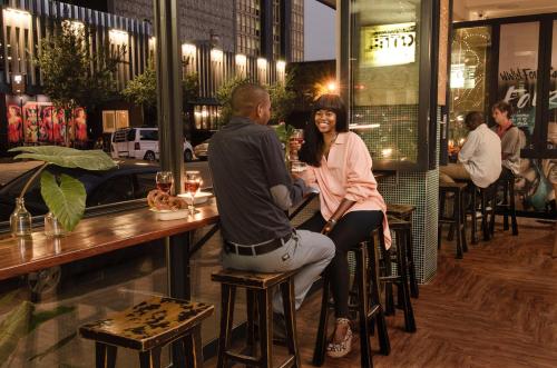 un hombre y una mujer sentados en una mesa en un restaurante en Bannister Hotel, en Johannesburgo