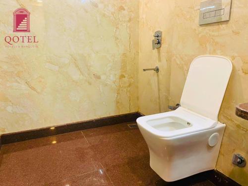 a bathroom with a white toilet in a room at Qotel Express Sandberry Prashant Vihar in New Delhi