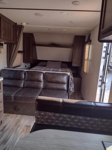 a living room with a couch and a bed in an rv at Branson RV Park in Branson