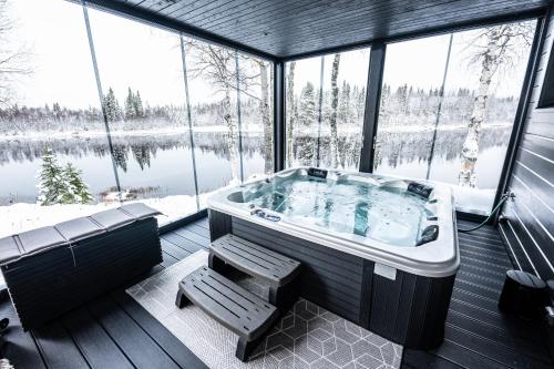 eine Whirlpool-Badewanne in einem Zimmer mit Fenstern in der Unterkunft Villa Wikkelä in Ranua