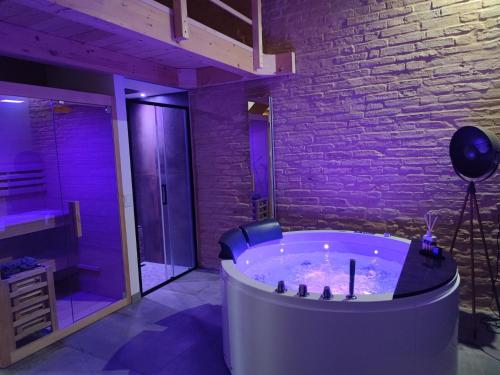 a hot tub in a room with a brick wall at Note di Rame in Castelfidardo