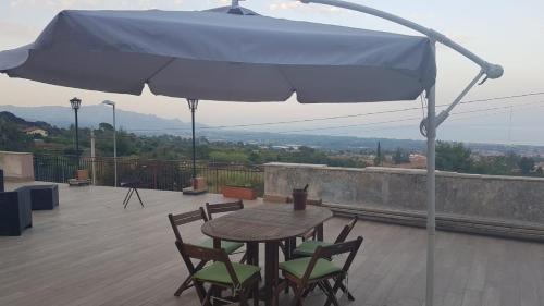 una mesa y sillas bajo una sombrilla en un techo en La TERRAZZA, en Nunziata