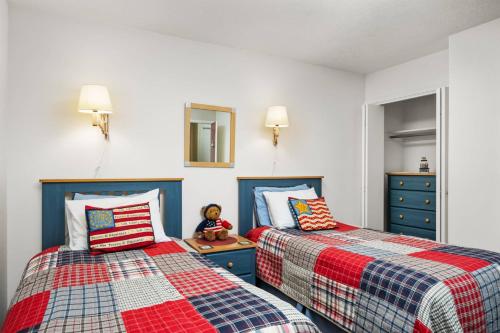 a bedroom with two beds and a teddy bear sitting on a night stand at Stars, Stripes, and Sand in Neskowin