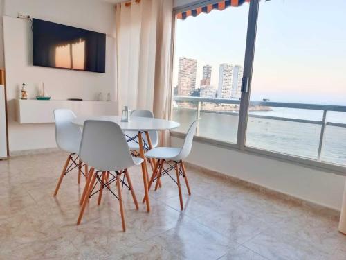 a dining room with a table and chairs and a large window at Benidorm Carolina Beach & Pool in Benidorm