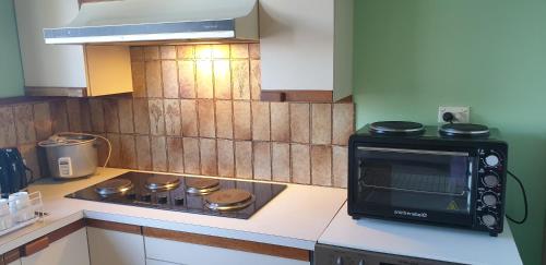 a kitchen with a microwave and a stove top oven at Standard Queen size bedroom in Little River