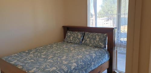 een klein bed in een kamer met een raam bij Standard Queen size bedroom in Little River