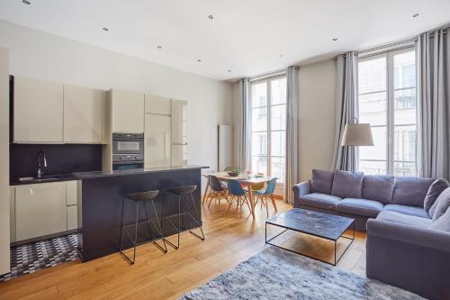 un salon avec un canapé et une cuisine dans l'établissement Apartment Ile Saint Louis by Studio prestige, à Paris