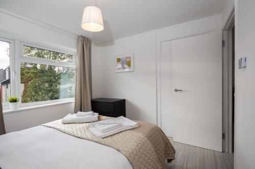 a bedroom with a bed with two towels on it at Stylish and Cosy 1 BDR Apt, Ealing Broadway in London