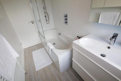 a white bathroom with a sink and a shower at Stylish and Cosy 1 BDR Apt, Ealing Broadway in London