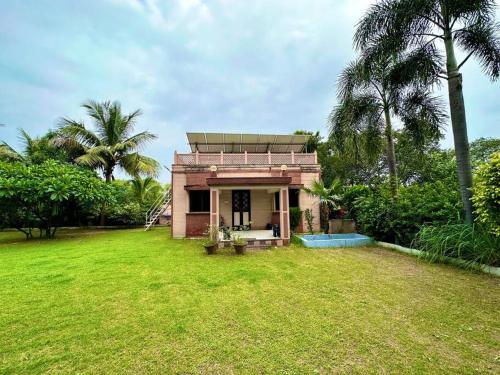 a small house in a field with a yard at Farm stay in Ahmedabad in Ahmedabad