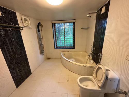 a bathroom with a toilet and a bath tub at Farm stay in Ahmedabad in Ahmedabad
