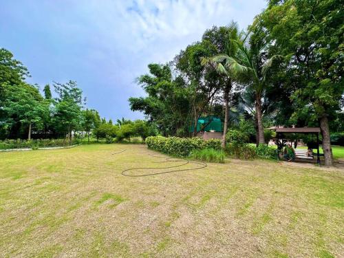 a hose laying on the grass in a park at Farm stay in Ahmedabad in Ahmedabad