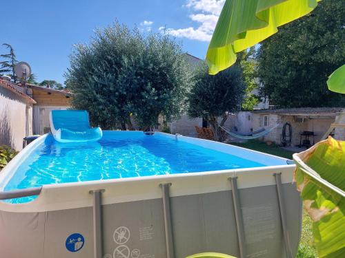 a swimming pool with a chair in it at Maison pour 6 personnes avec piscine et proche de la plage in Aytré