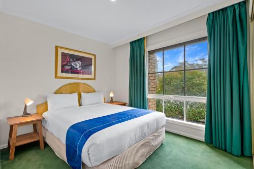 a bedroom with a bed and a large window at Rowville International Hotel in Rowville