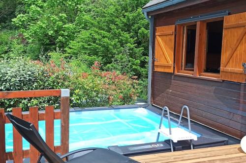 a small swimming pool next to a house at Le Chalet du lac avec spa et piscine privés pour le printemps et l'été et poêle à bois réconfortant en hiver in Beaulieu