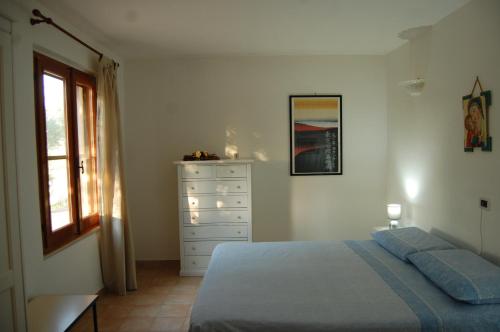 1 dormitorio con 1 cama, vestidor y ventana en Casa Vacanze La Rosa e L'Ulivo, en Faiti