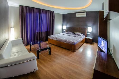 1 dormitorio con 1 cama, TV y sofá en Бульвар Леси Украинки 16 джакузи люкс центр, en Kiev