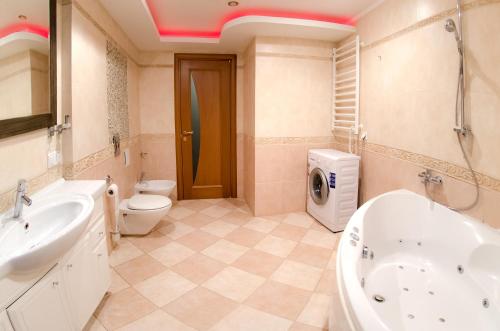 ein Badezimmer mit einem Waschbecken und einer Waschmaschine in der Unterkunft Бульвар Леси Украинки 16 джакузи люкс центр in Kiew
