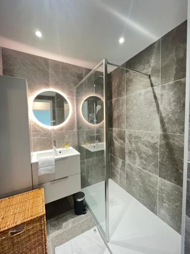 une salle de bain avec une douche en verre et un lavabo dans l'établissement Les yeux dans le bleu, Cannes Vue mer, à Cannes