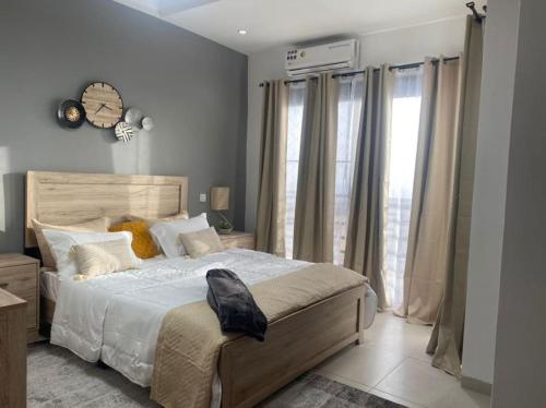 ein Schlafzimmer mit einem großen Bett und einem großen Fenster in der Unterkunft Studio confortable au 7e étage in Dakar