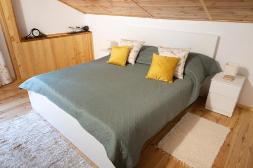 1 dormitorio con 1 cama grande con almohadas amarillas en Zielona Zagroda Agnieszka Połeć, en Poświętne