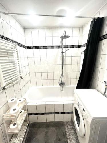 a bathroom with a tub and a washing machine at Traum Fewo in idyllischer Lage in Ganderkesee