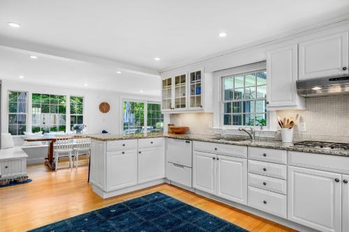 a kitchen with white cabinets and a blue rug at 55 Wianno Circle Osterville - O Captain My Captain in Osterville
