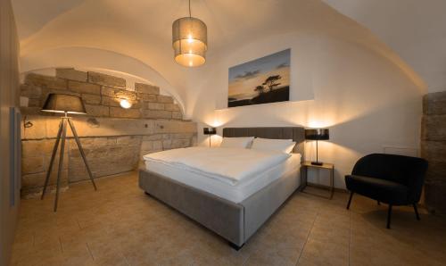 a bedroom with a bed and a lamp and a chair at Pension Donatus in Pirna