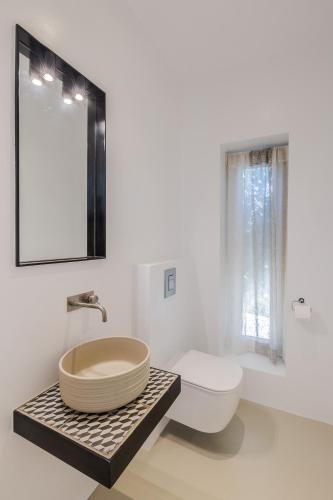 a bathroom with a sink and a toilet and a mirror at Luxury Villa Gialova Neokastro with Private Pool in Gialova