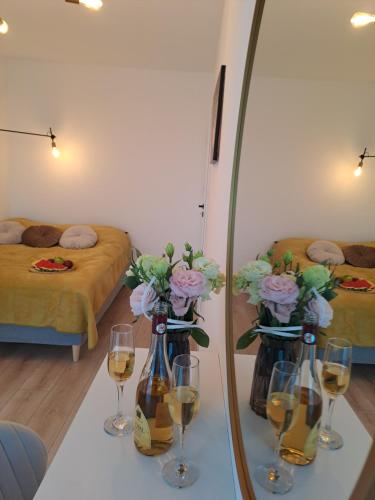 a room with a table with wine glasses and a mirror at Apartament Aleje Józefa Piłsudskiego in Nowy Sącz