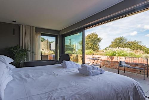 a bedroom with a large white bed with towels on it at The Hayloft by Bloom Stays in Canterbury